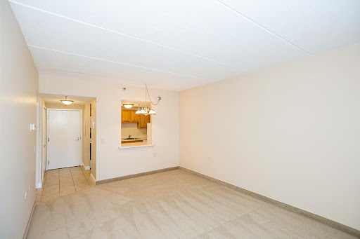 A bright and spacious empty living room, featuring neutral tones and an open layout.