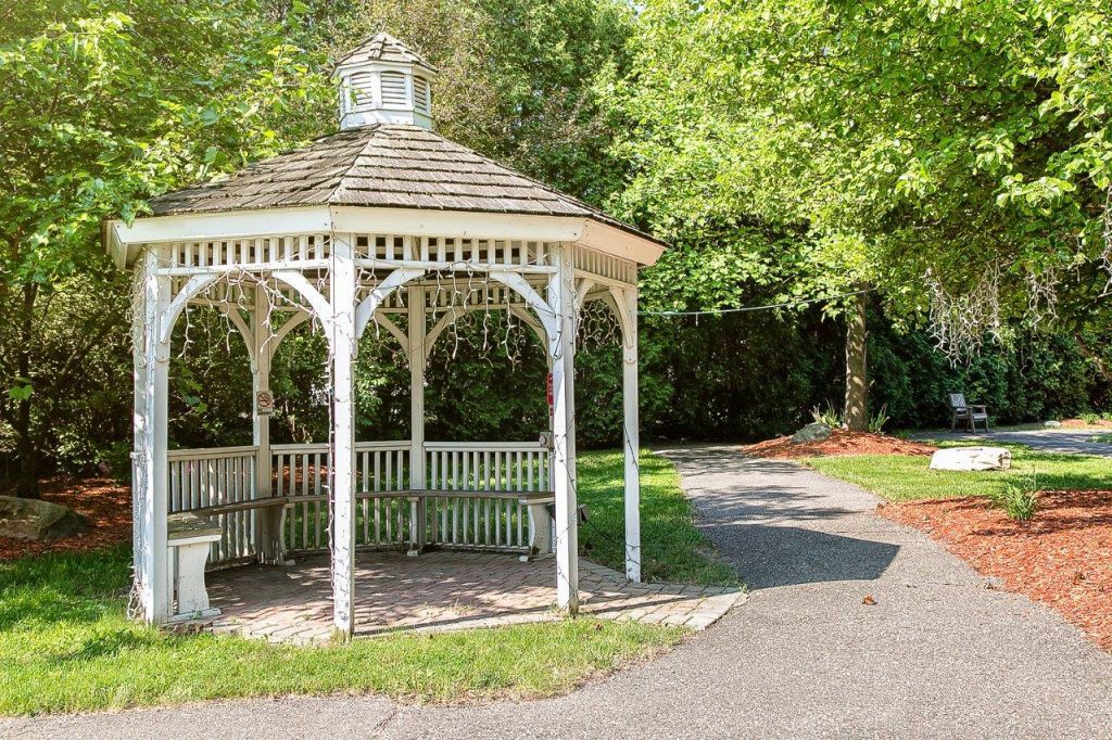 A quaint gazebo nestled in a lush, green park setting.