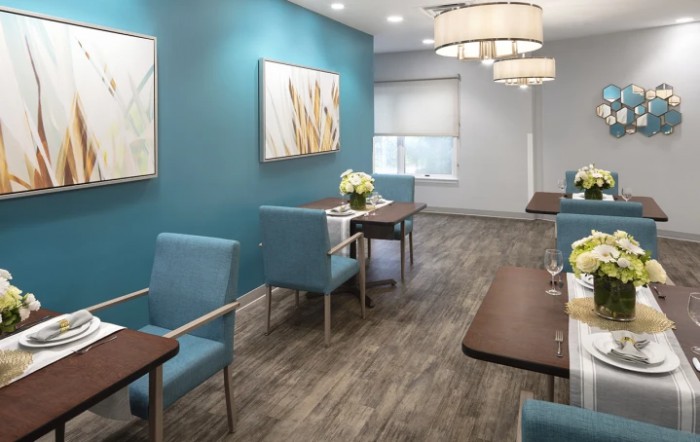 A modern waiting room with blue walls, stylish lighting, and comfortable seating.