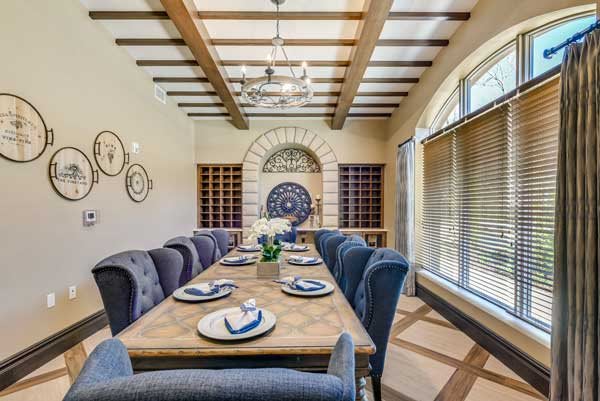 Elegant dining room with a large wooden table, plush chairs, and decorative place settings.