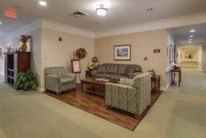 A cozy living room area with a sofa, two chairs, and a coffee table on a wooden floor.