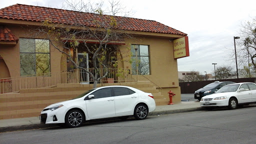A white car parked in front of a building with a red-tiled roof.