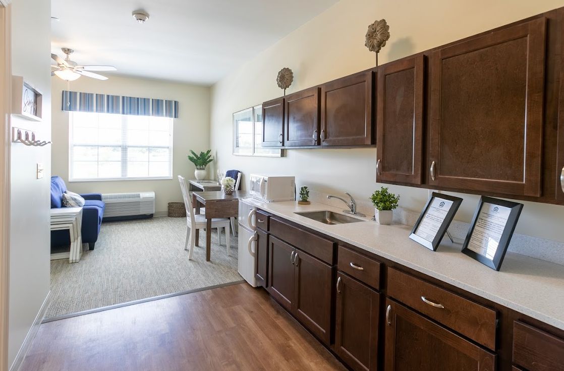 A modern kitchen and dining area with dark wood cabinets and contemporary furnishings.
