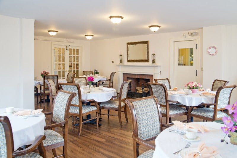 A well-decorated dining room featuring elegant tables and chairs set for a meal.