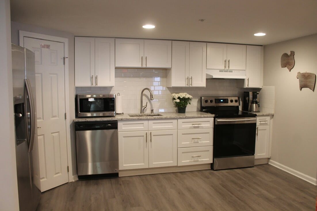 A modern kitchen with white cabinets and stainless steel appliances.