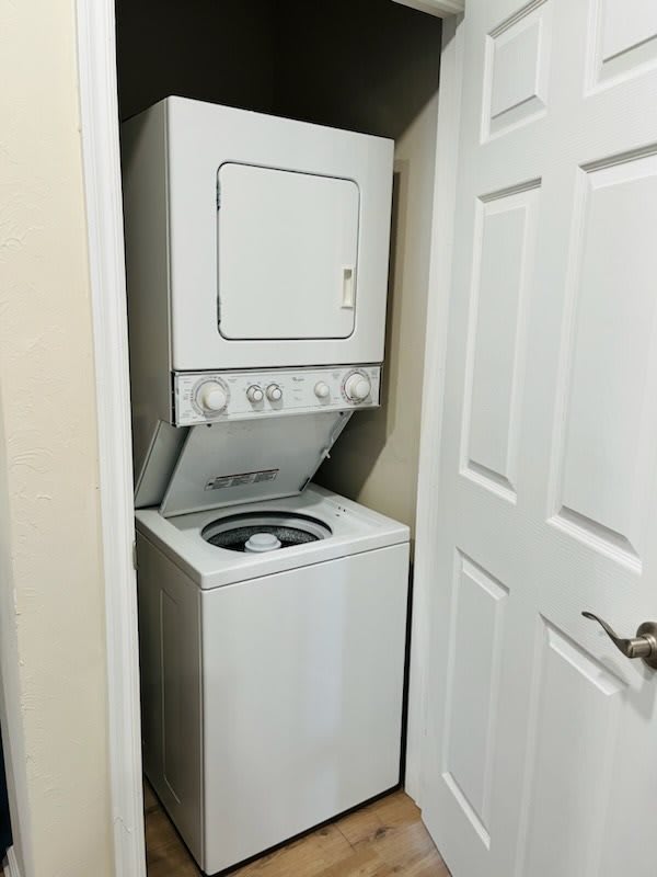 A compact, stacked washer and dryer unit in a small laundry space.