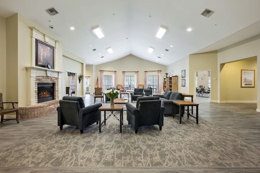 A spacious and modern lounge area featuring comfortable seating, a fireplace, and ample natural lighting.