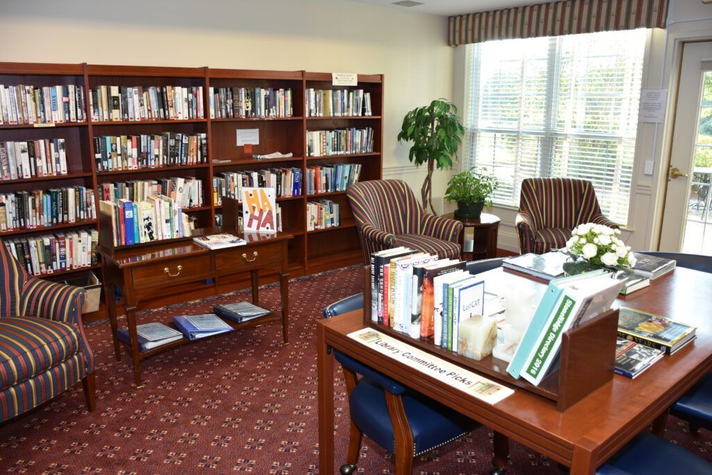 A cozy indoor library with bookshelves, tables, and chairs for reading.