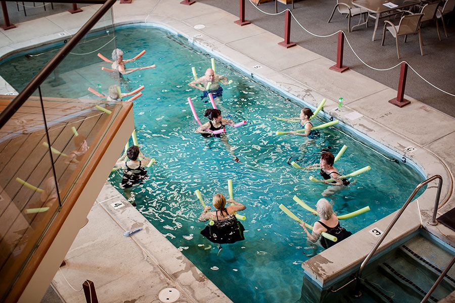 A group of people participating in a water aerobics class in a swimming pool.