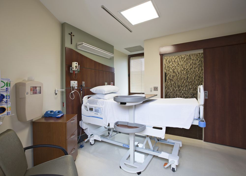 A modern hospital room with a medical bed and equipment.