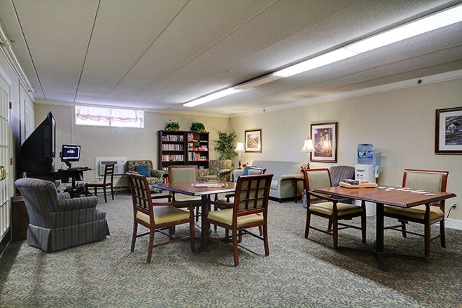A cozy lounge with comfortable seating, bookshelves, and warm lighting.