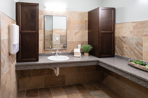 A modern bathroom showcasing a clean sink area with wooden cabinets and natural decor.