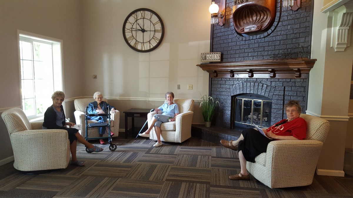 A group of people sitting in a cozy living room with a fireplace.
