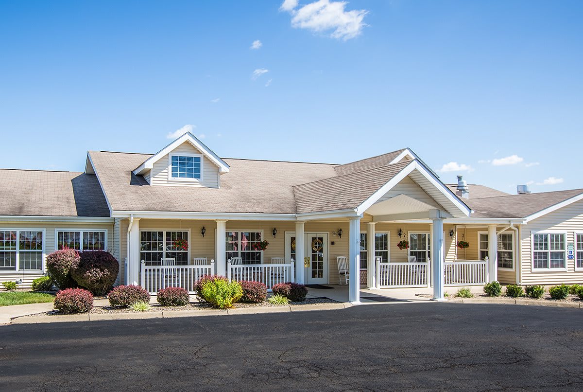 A single-story residential building with a porch and landscaped surroundings.