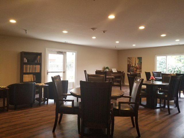 A cozy reading room with tables and chairs arranged for group activities or quiet study.