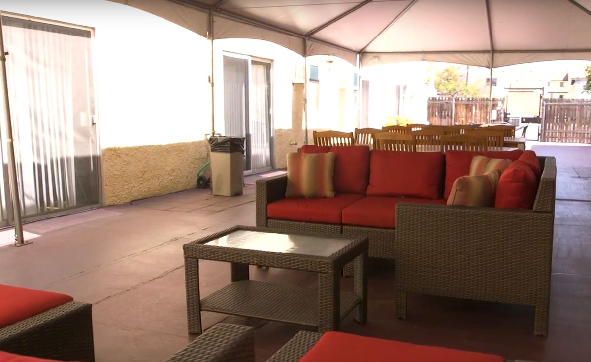 An outdoor patio with comfortable seating, including a sofa and table.