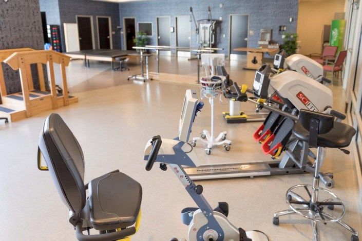 A spacious gym with various exercise equipment and cardio machines.