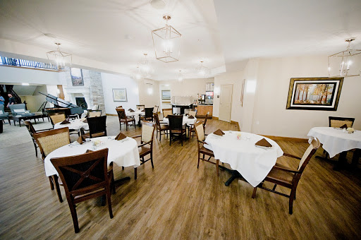 A spacious and elegantly designed dining area, featuring neatly arranged tables and comfortable seating.