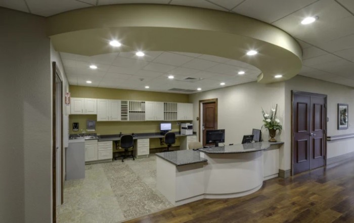 A modern office reception area featuring a curved desk and multiple computer workstations.
