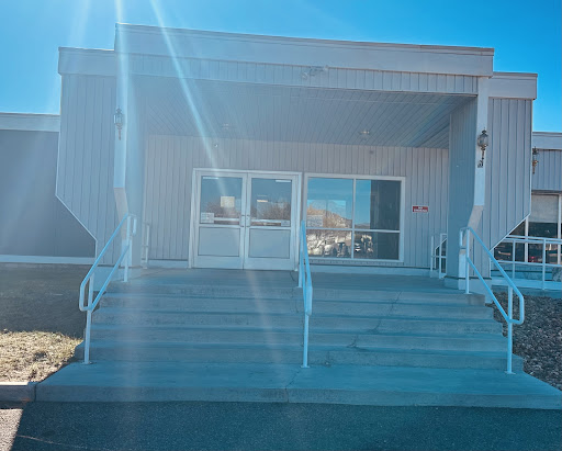 A modern building entrance with steps leading up to the glass doors.