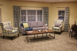 A cozy living room with a sofa, armchairs, and a coffee table.