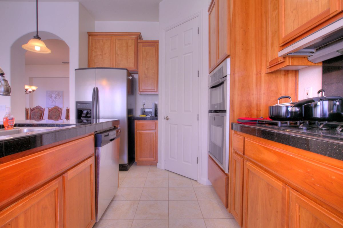 A modern kitchen with wooden cabinets and stainless steel appliances.