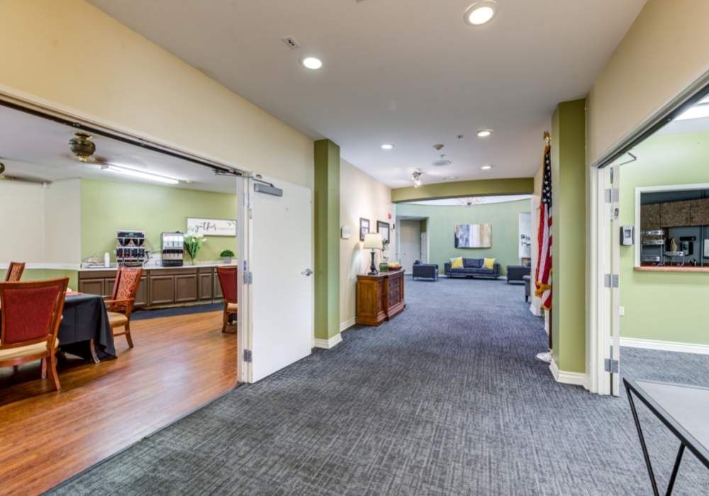 A spacious hallway in an office building with a waiting area and open doors leading to other rooms.