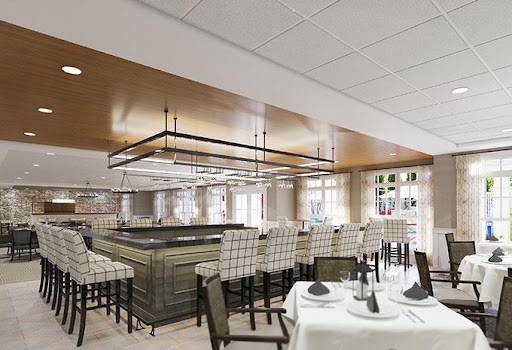 A contemporary restaurant interior featuring a sophisticated bar area and elegantly set dining tables.