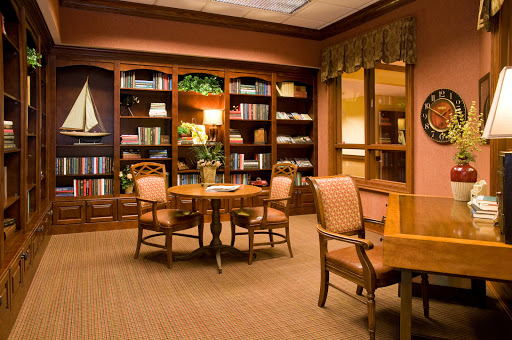 A cozy library space featuring wooden bookshelves, comfortable seating, and warm lighting, perfect for reading or studying.