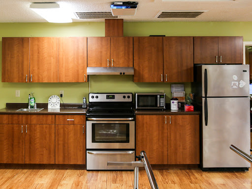 A modern kitchen featuring stainless steel appliances and wooden cabinets.