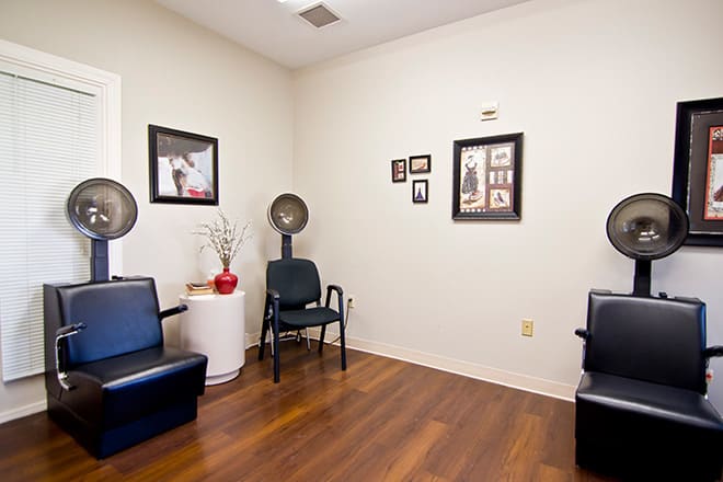 A cozy waiting area in a hair salon with chairs and decorative wall art.
