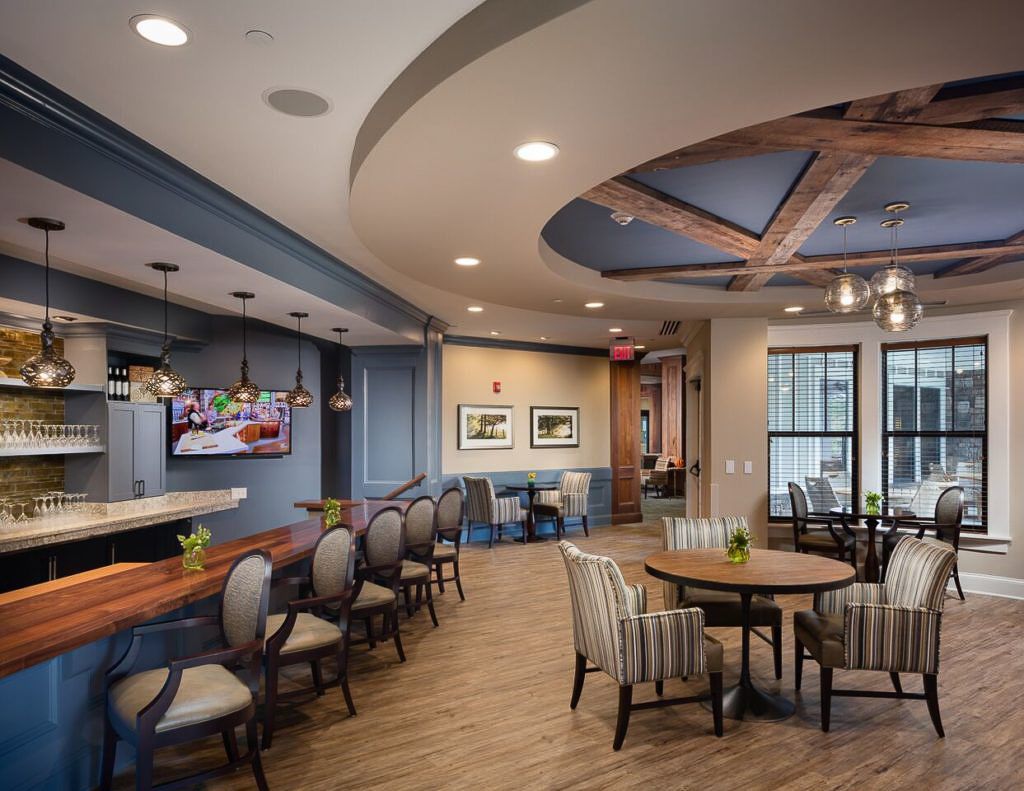 A modern interior featuring a kitchen and dining area with elegant seating and wood flooring.