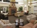 A cozy lobby with comfortable seating and a central fireplace.