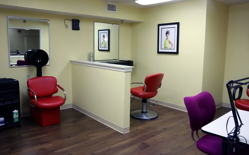 A modern hair salon interior with colorful chairs and wall art.