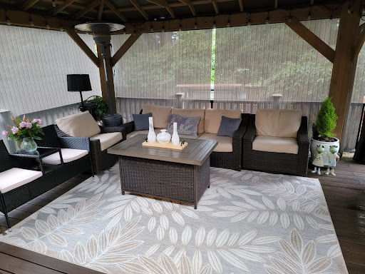 A cozy outdoor seating area featuring comfortable furniture under a gazebo.