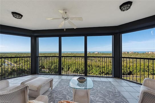 A modern living space with a cozy seating area overlooking an expansive ocean view through large glass windows.