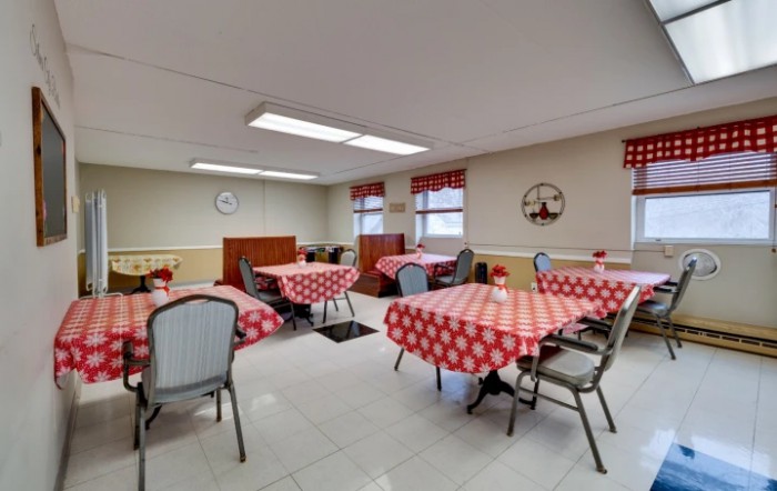 A cozy dining room with checkered tablecloths and simple decor.