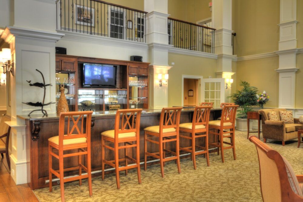 A cozy bar area with wooden chairs and a television in a well-decorated lobby.