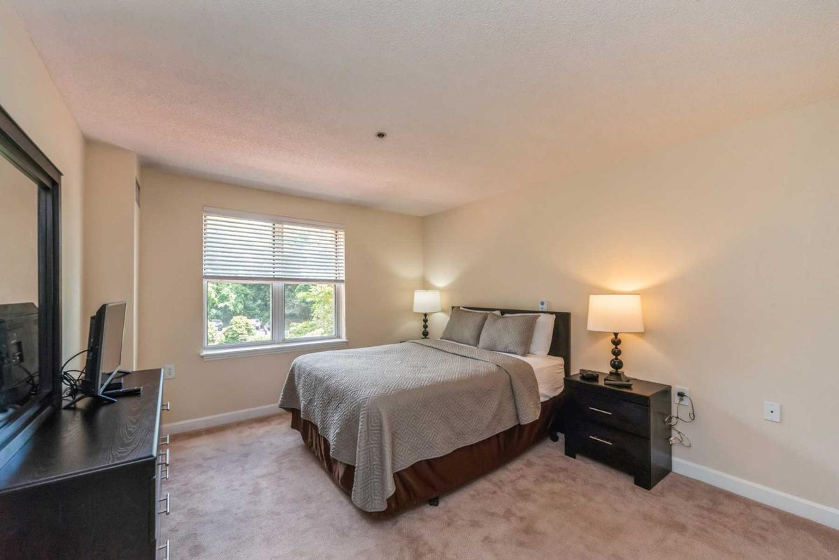 A cozy bedroom with a bed, nightstands, and soft lighting.