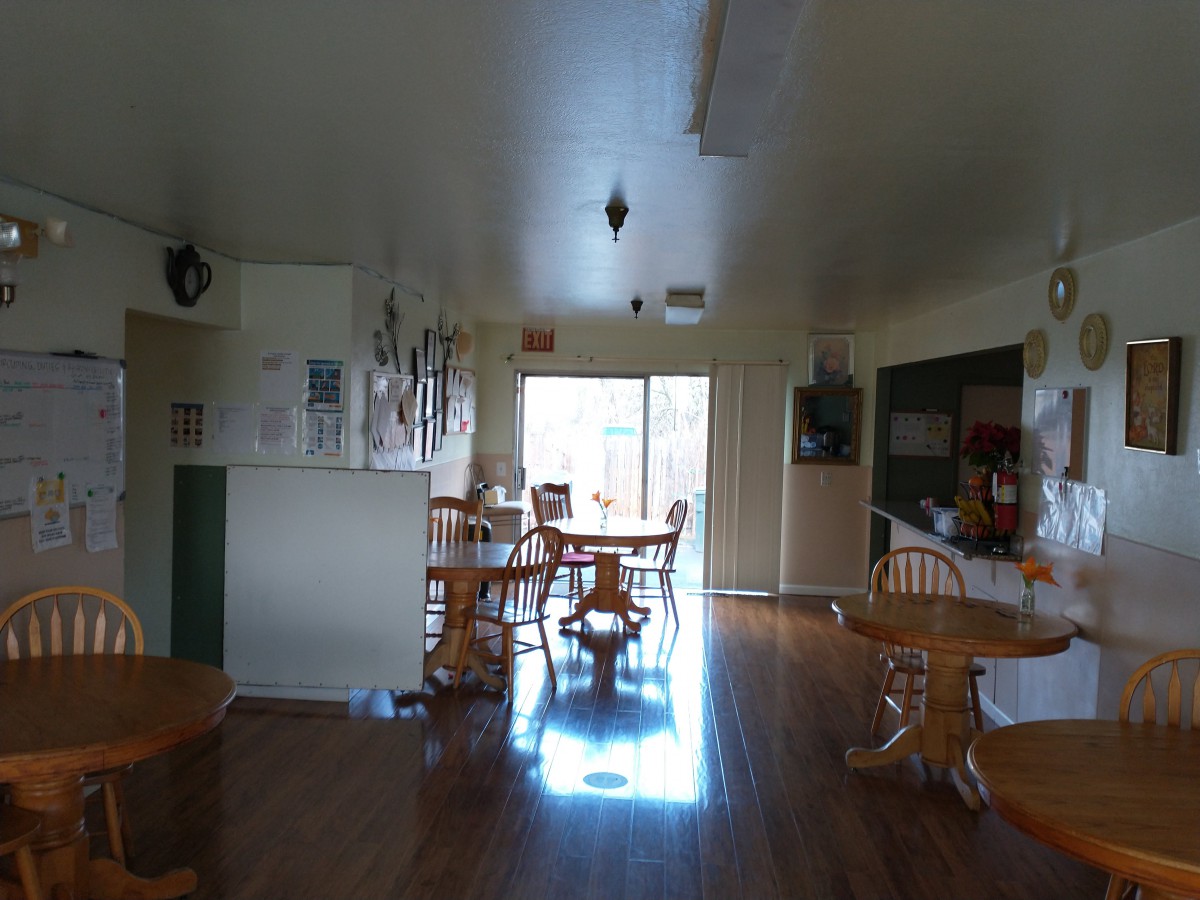 A cozy kitchen and dining area with wooden furniture and ample natural light.