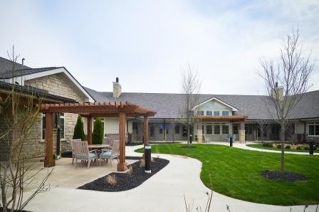 A modern building with a landscaped lawn and patio area.