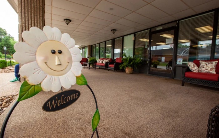 A welcoming entrance with a cheerful flower decoration and outdoor seating.