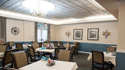 A cozy dining area with neatly arranged tables and comfortable chairs, featuring soft lighting and tasteful decor.