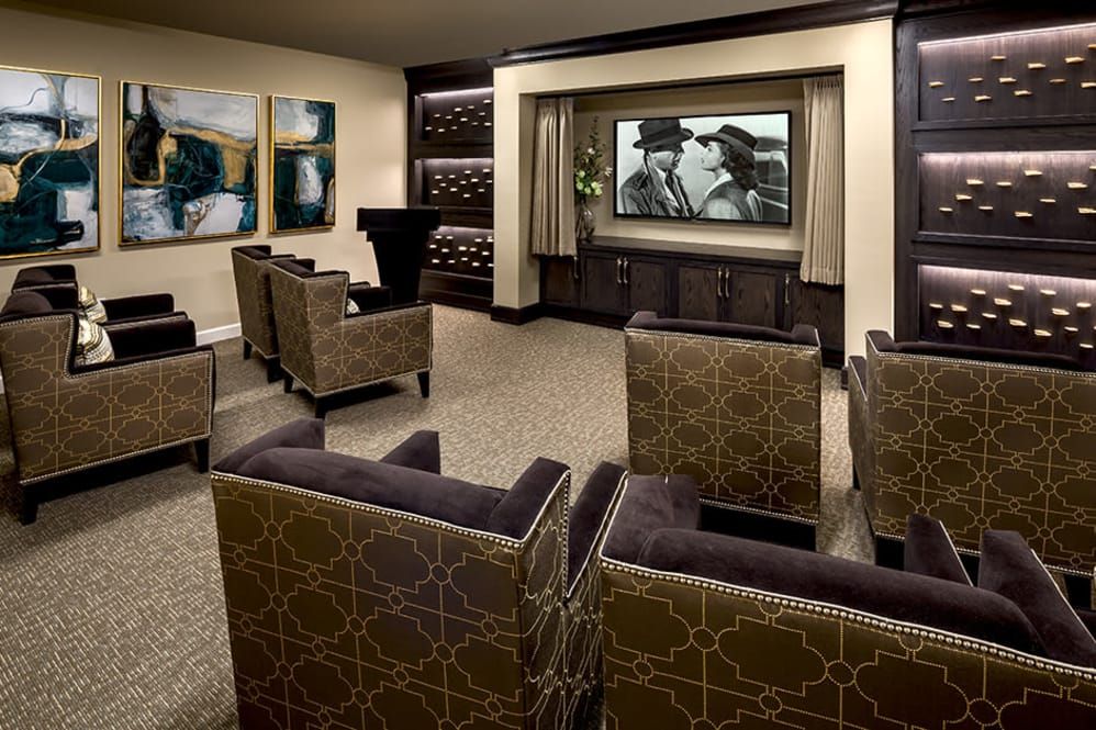 A luxurious home theater with elegant seating and artwork on the walls.