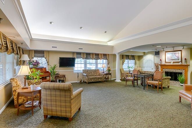 A cozy living room with comfortable seating, a television, and decorative plants.
