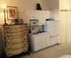 A cozy room featuring a wooden drawer and a modern white cabinet with decorative items.