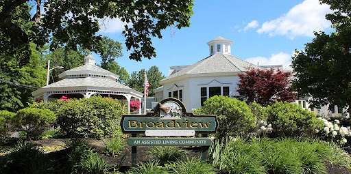 A welcoming entrance sign to the Brookhaven community, surrounded by lush greenery and a beautiful building in the background.