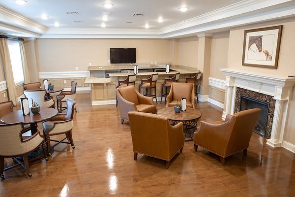 A modern lounge area with comfortable seating, a television, and a fireplace.