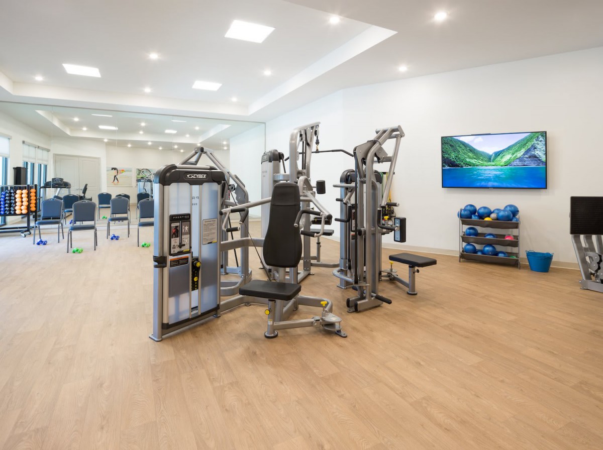 A modern gym with a variety of fitness equipment and exercise machines.