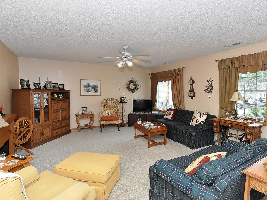 A cozy living room with a seating arrangement, wooden furniture, and decorative items.